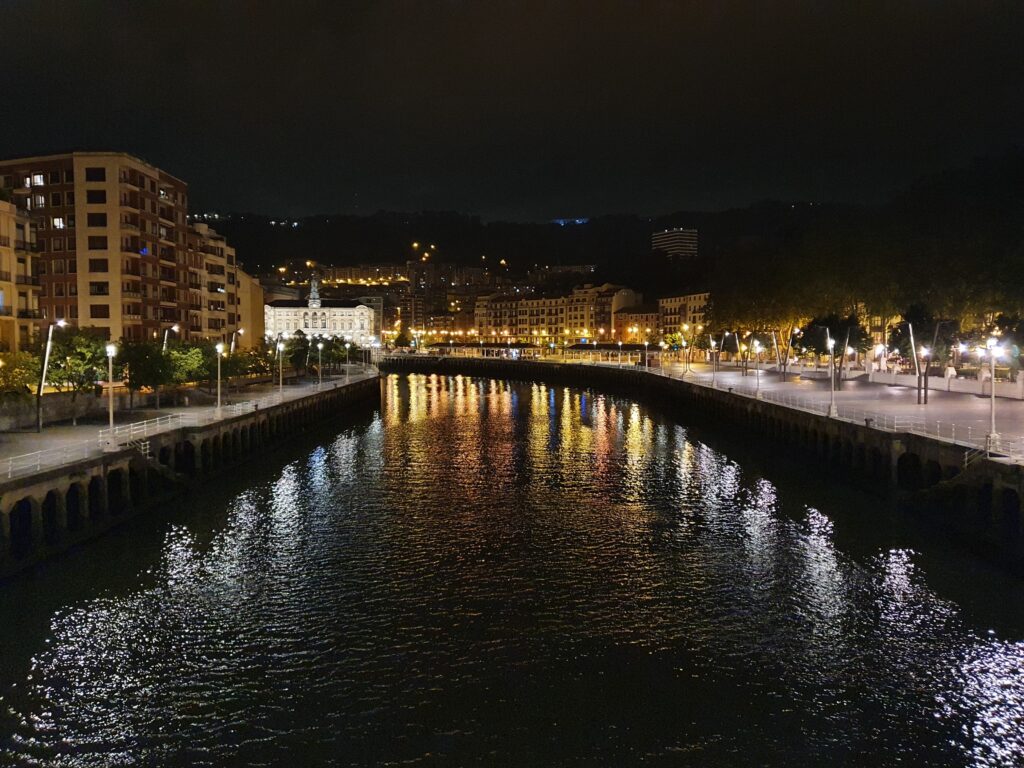 Nocny widok na rzekę Nervion i oświetlone miasto