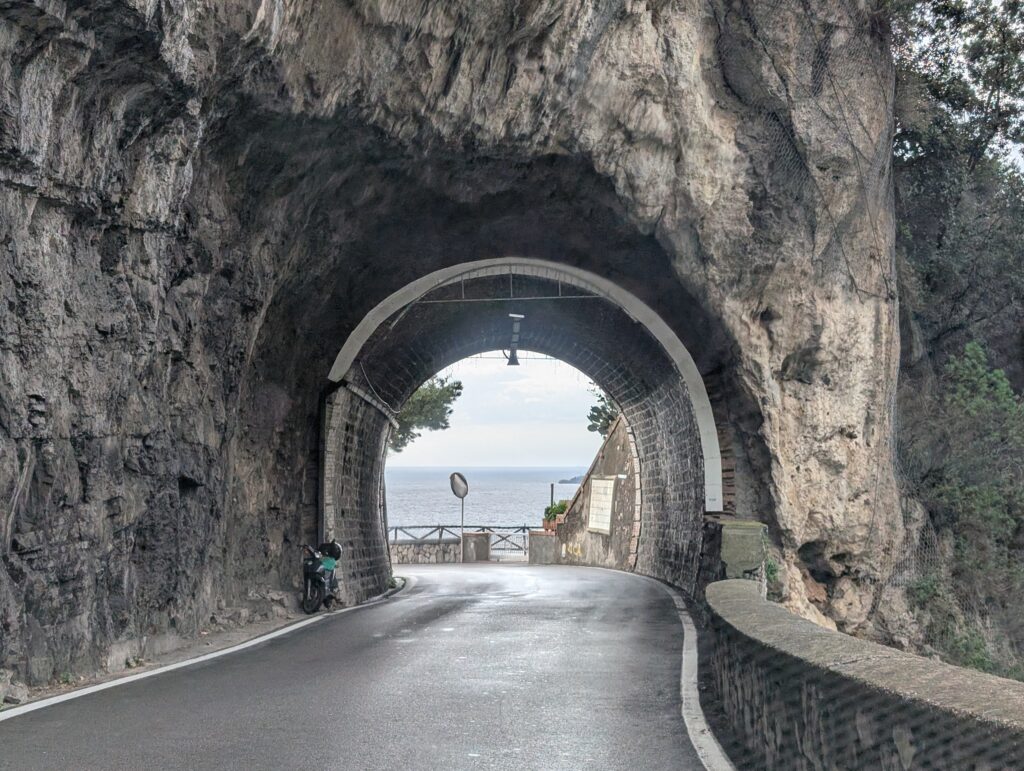Tunel wykuty w skale na krętej drodze SS163 Amalfi Road.