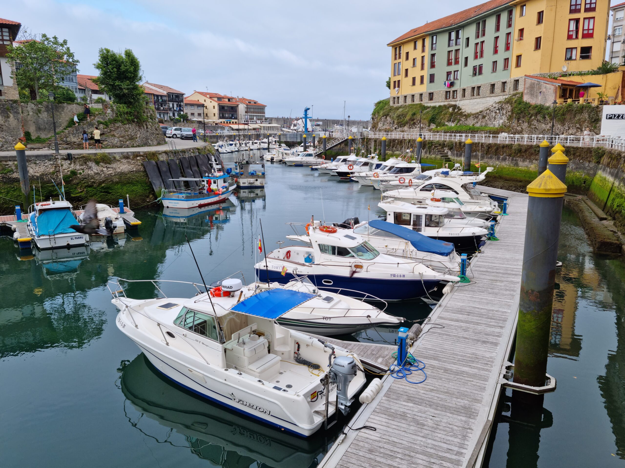Kolorowe łodzie w porcie w Llanes podczas słonecznego dnia, Asturia.