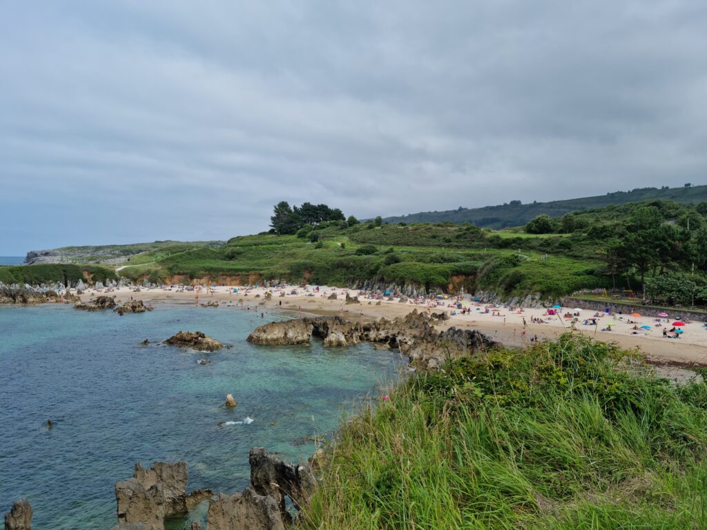 Panorama plaży Playa de Toro z zielonym wzgórzem w tle