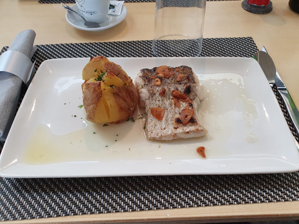 Grillowana ryba z pieczonym ziemniakiem na talerzu