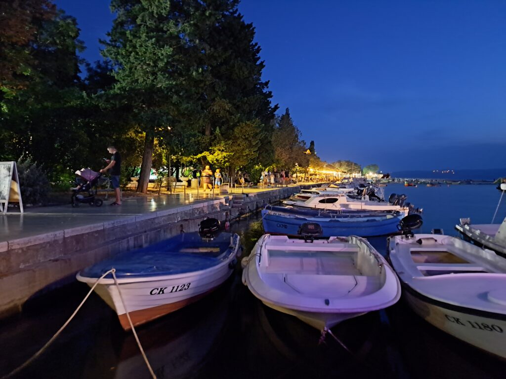 Nocny widok na promenadę w Selce z łodziami na pierwszym planie