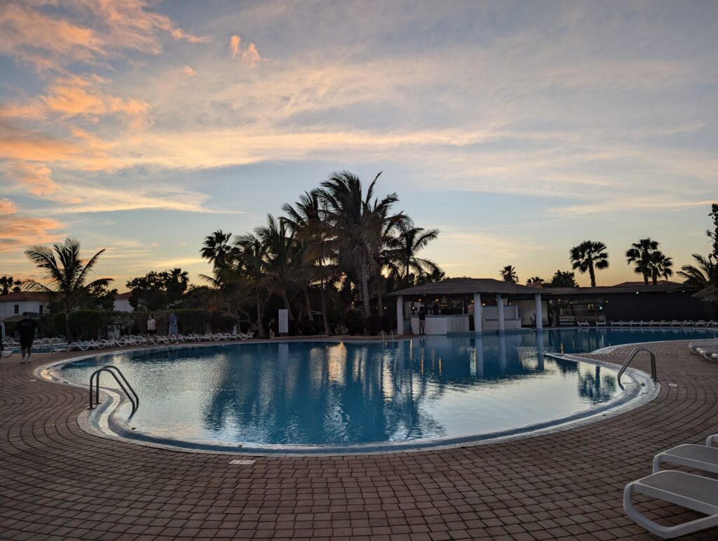 Główny basen w hotelu Melia Tortuga Beach o zachodzie słońca w otoczeniu palm