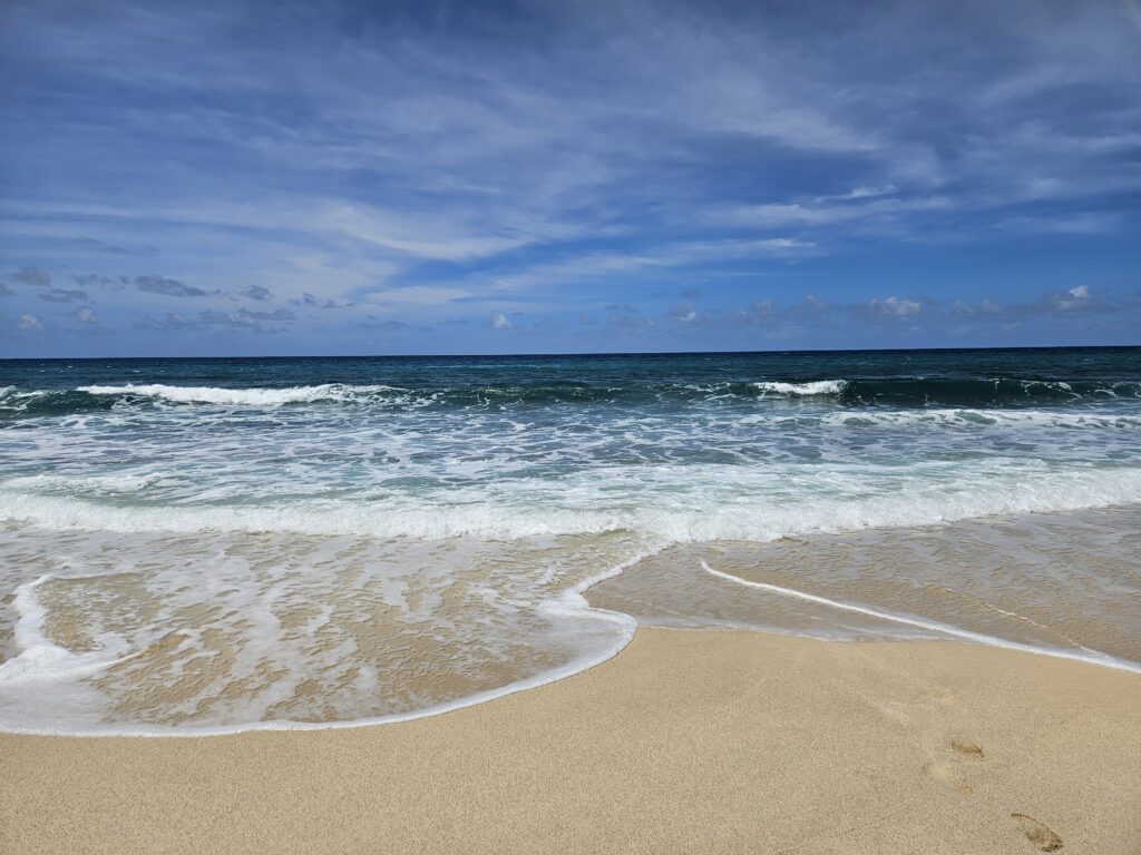 Silne fale oceanu rozbijające się o piaszczystą plażę na wyspie Sal