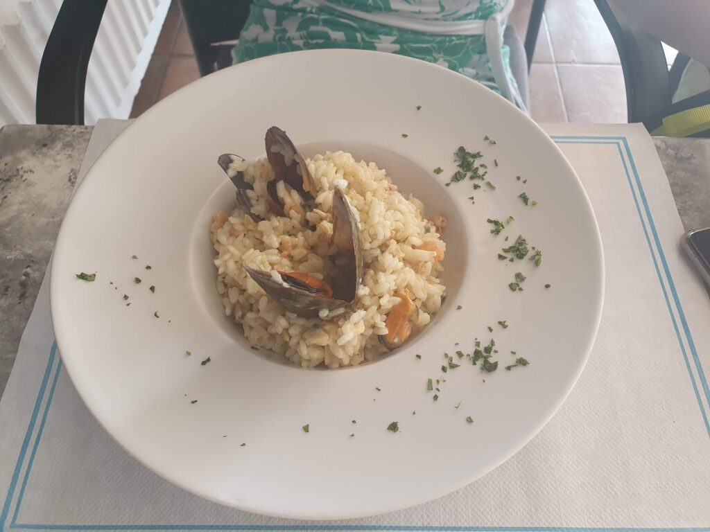 Risotto z owocami morza i małżami podane w głębokim talerzu 