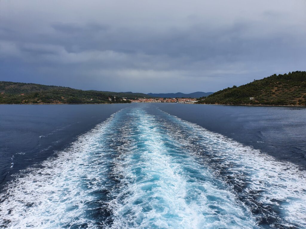 Kilwater promu wypływającego szerokim kanałem z portu Vela Luka w Chorwacji.