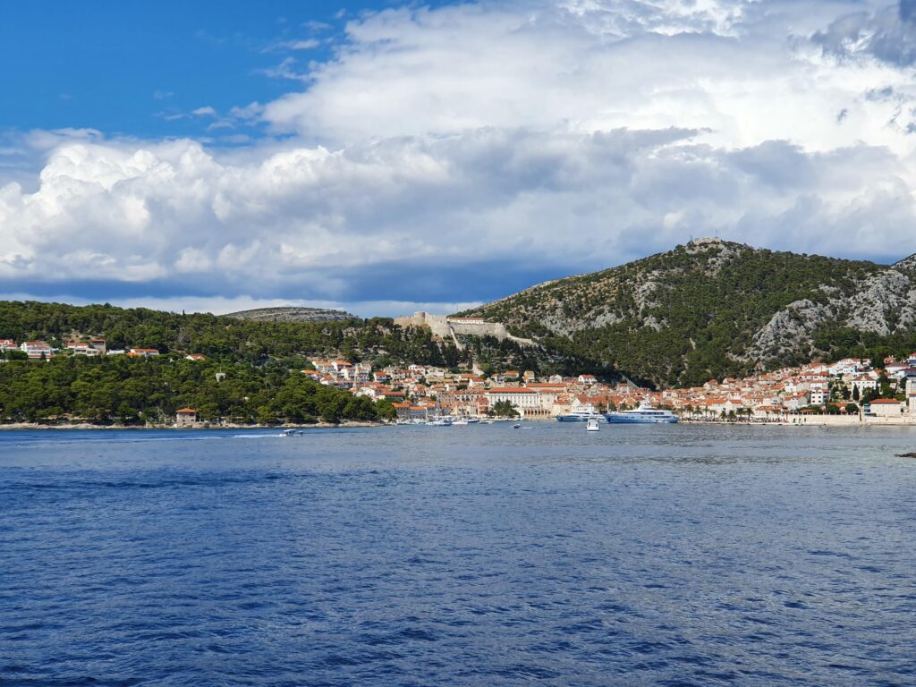Widok z pokładu promu na miasto Hvar i twierdzę na wzgórzu