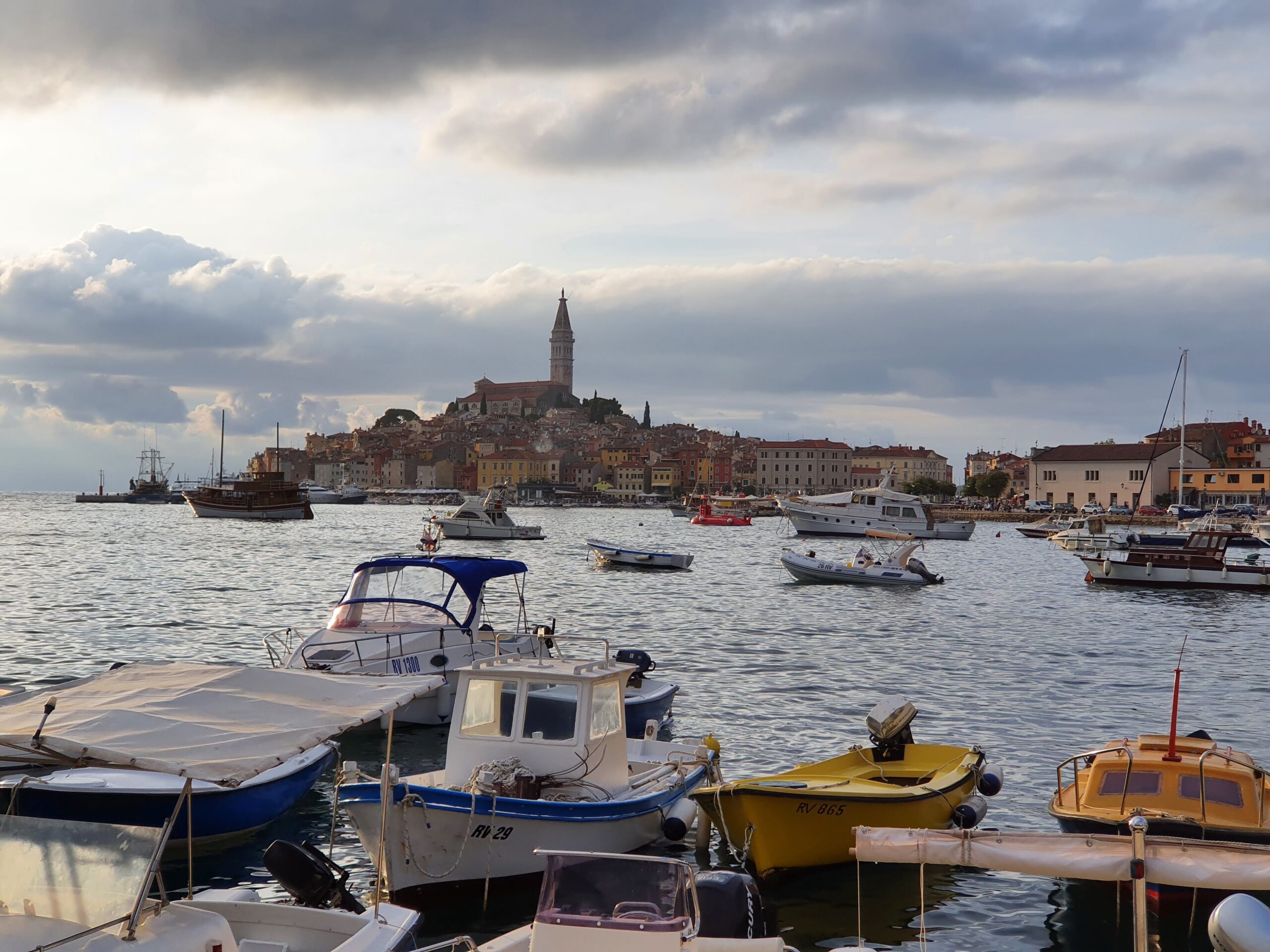 Widok na starówkę i port w Rovinj o zachodzie słońca pod zachmurzonym niebem