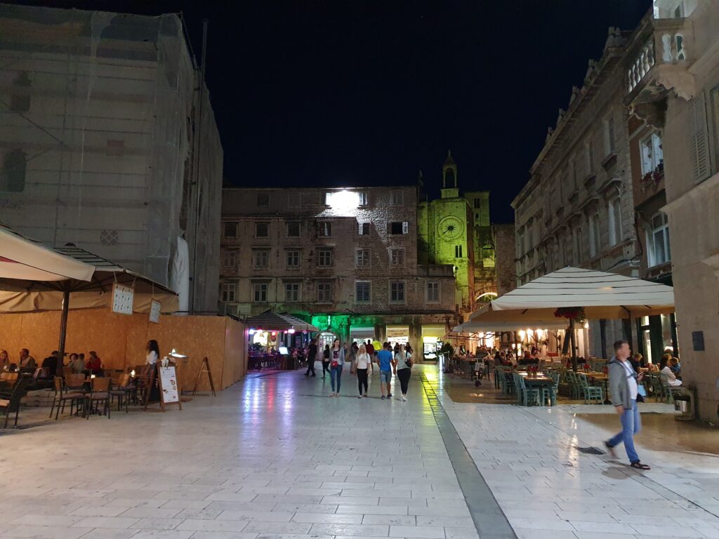 Plac Ludowy w Splicie nocą z kawiarnianymi parasolami