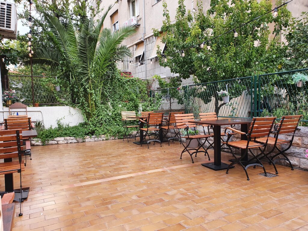 Ogródek restauracyjny Šug Restaurant w Splicie z drewnianymi meblami