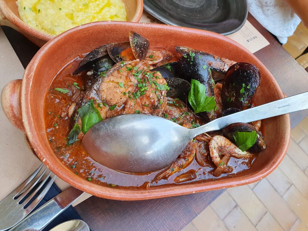 Gulasz rybny z małżami i krewetkami w glinianym naczyniu w restauracji Šug
