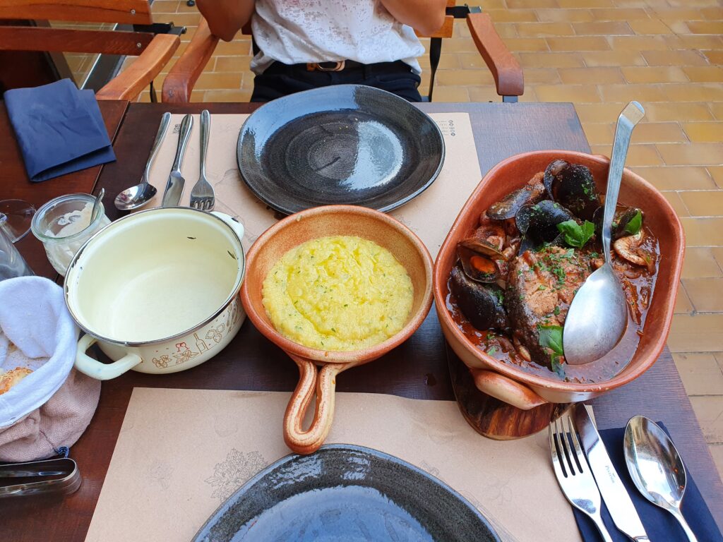 Szeroki kadr stołu w Šug Restaurant z pełnym zamówieniem dań