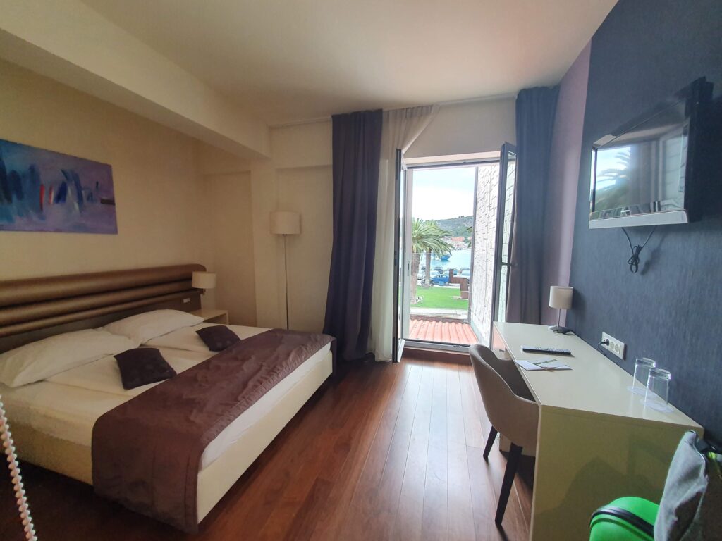 Jasny i nowoczesny pokój hotelowy w Hotelu Korkyra z widokiem na port.