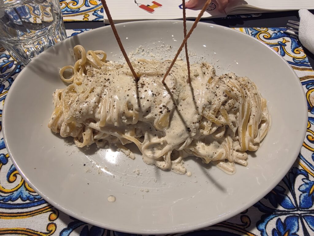 Gęste i kremowe spaghetti cacio e pepe z truflami w głębokim talerzu