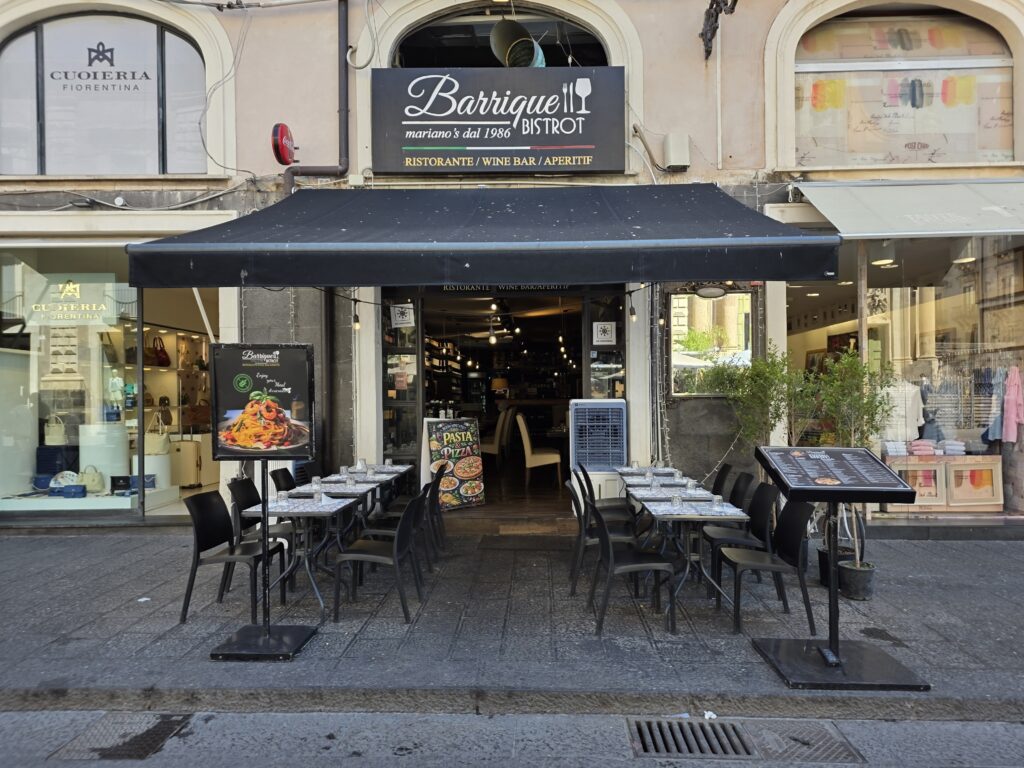 Fasada restauracji Barrique Bistrot z czarną markizą i stolikami na zewnątrz