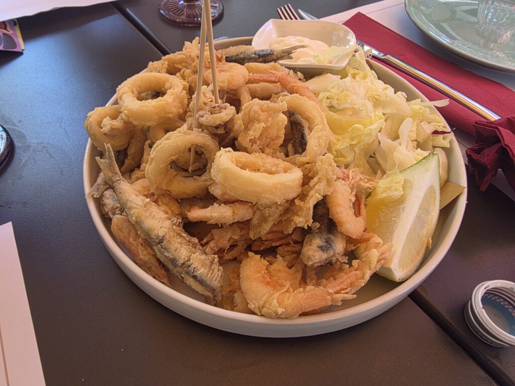 Duży talerz fritto misto ze smażonymi krewetkami, kalmarami i małymi rybkami