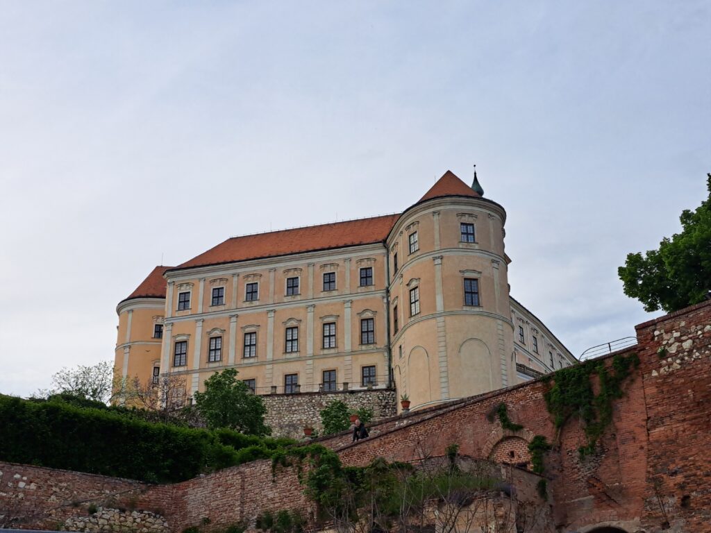 Monumentalny barokowy zamek w Mikulovie wznoszący się nad kamiennym murem