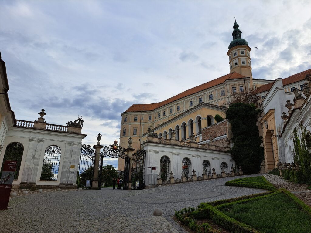 Klasyczna bryła zamku w Mikulovie z wieżą zegarową i ozdobną bramą wjazdową