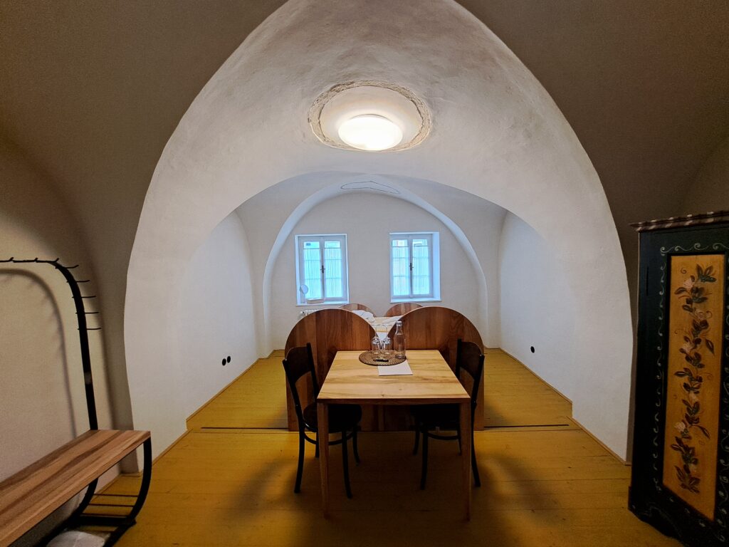 Unikalna sypialnia w pensjonacie Štajnhaus ze sklepieniem łukowym i drewnianymi elementami