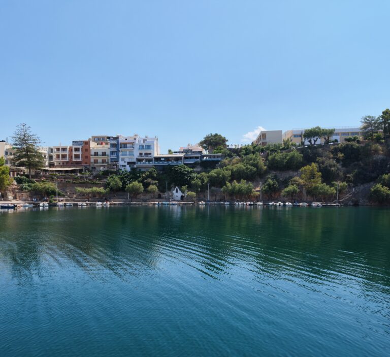 Szmaragdowe wody jeziora Voulismeni otoczone stromymi klifami w centrum Agios Nikolaos na Krecie.