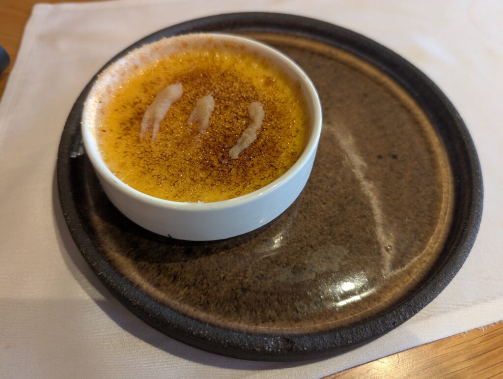 Klasyczny deser creme brulee w białej kokilce z przypaloną warstwą cukru
