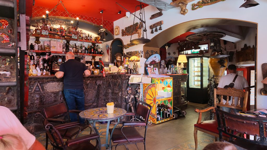 Kolorowe wnętrze Bar Turrisi w Castelmoli z drewnianym barem i dekoracjami